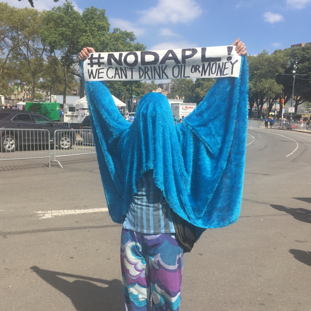 In Philadelphia a protester stands in solidarity with Native American demonstrators in North Dakota fighting to stop the Dakota Access oil pipeline. About 100 people protested at Obama's rally in Center City Philadelphia on Tuesday