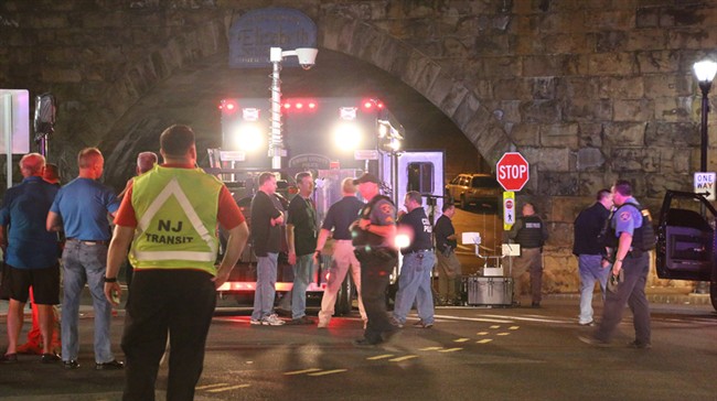 Bomb squad personnel stand around the scene of an explosion near the train station early Monday Sept 19 2016 in Elizabeth N.J. A suspicious device found Sunday night in a trash can near a New Jersey train station exploded early Monday as a bomb squad