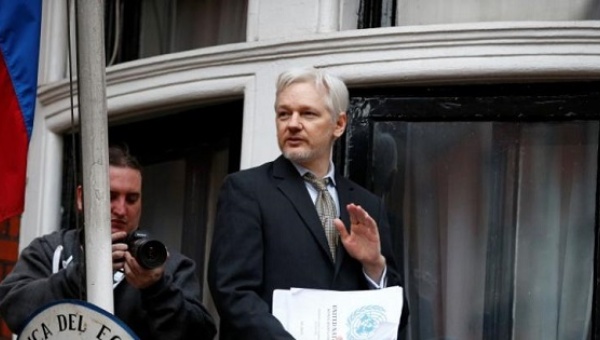 WikiLeaks founder Julian Assange holds a copy of a U.N. ruling as he makes a speech from the balcony of the Ecuadorian Embassy in central London Britain