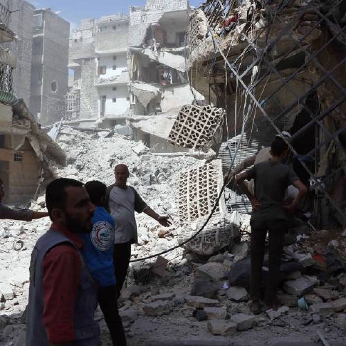 Syrian Civil Defense White Helmets men stand amid rubble after airstrikes in al Mashhad neighborhood in the rebel-held part of eastern Aleppo Syria Wednesday Sept. 21 2016. Ibrahim Alhaj a member of the volunteer