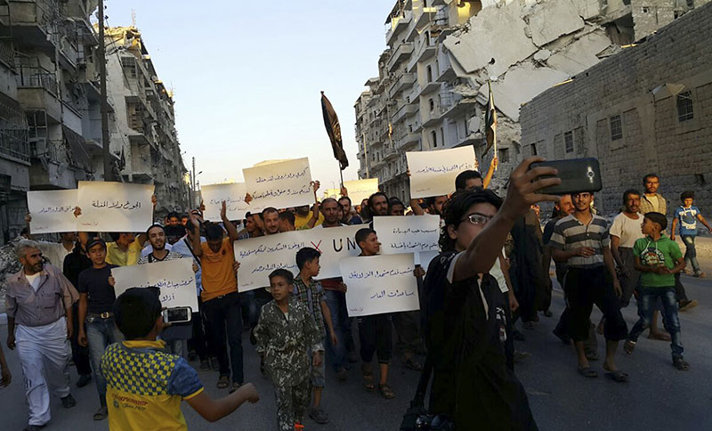 FILE- Activists in Syria's besieged Aleppo protest against the United Nations for what they say is its failure to lift the siege off their rebel-held area in Aleppo Syria