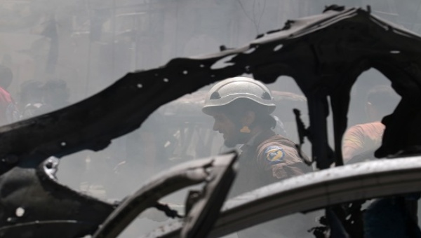 A civil defence member reacts in a damaged site near the frame of a burnt vehicle after an airstrike on al Jalaa street in the rebel held city of Idlib Syria