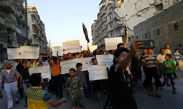 Activists in Syria’s besieged Aleppo protest against the United Nations for what they say is its failure to lift the siege off their rebel-held area Tuesday Sept. 13 2016. Dozens of protesters marched in al Shaar neighborhood heading toward the Cast