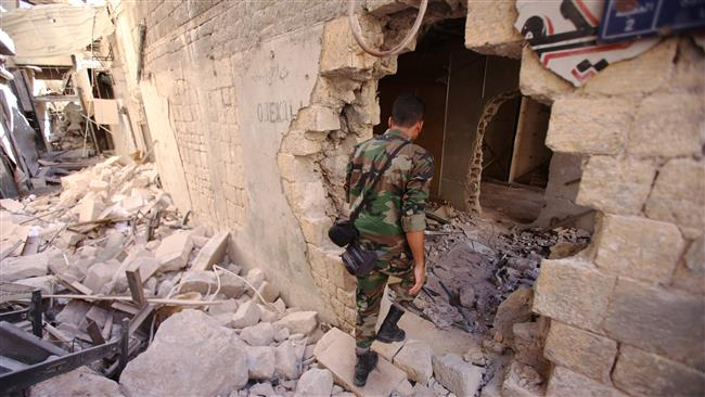 A Syrian government soldier walks in the damaged al Farafira Souk in the government-held part of Aleppo northwestern Syria