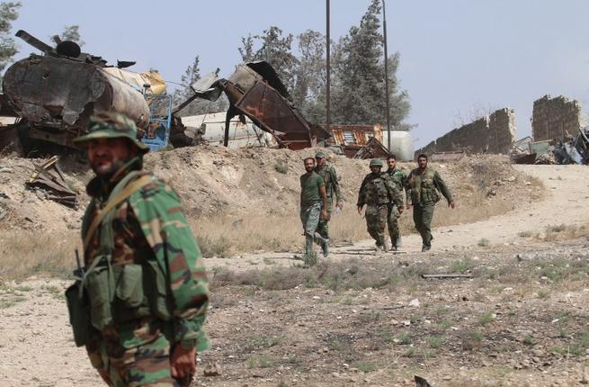 Syrian pro-regime fighters patrol the Ramussa area south of the city of Aleppo