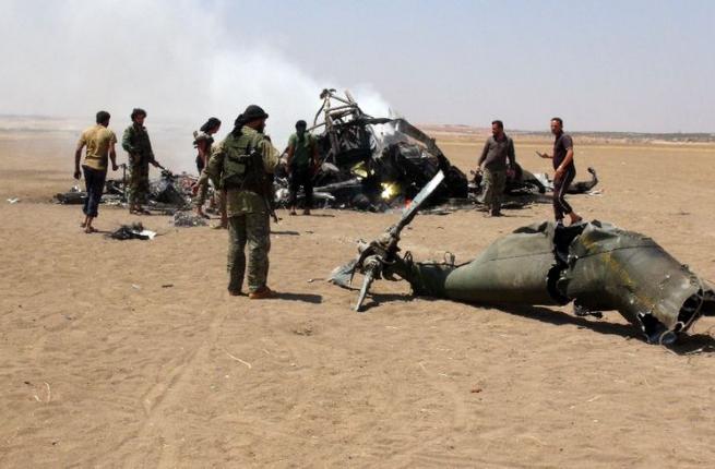 Syrian rebels gather around the wreckage of a Russian Mi-8 military transport helicopter