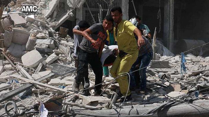 Syrians carrying a victim after barrel bombs were dropped on the Bab al Nairab neighborhood in Aleppo