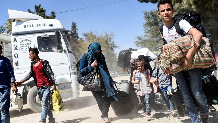 Syrian refugees walk on their way back to the Syrian city of Jarabulus