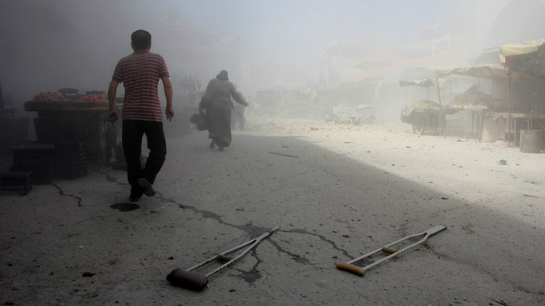 Syrians run away from the scene of a reported air strike on the rebel-held northwestern city of Idlib