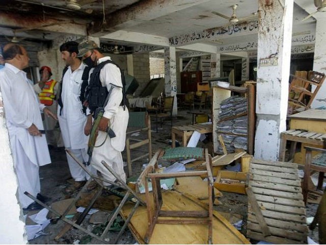 Pakistani officials examine a site of a bombing in Mardan Pakistan Friday Sept. 2 2016. Northwestern Pakistan was struck by two separate militant attacks on Friday when gunmen wearing suicide vests stormed a Christian colony near the town of Peshawar