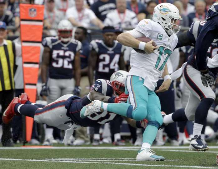 Dolphins quarterback Ryan Tannehill tries to avoid a tackle by Patriots linebacker Jamie Collins during the Sept. 18 game in Foxborough Mass. Tannehill is the leading rusher for the struggling Dolphins with 52 yards. Associated Press