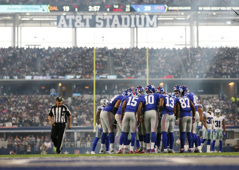 The New York Giants huddle under the setting sun at AT&T Field. Credit Erich Schlegel-USA TODAY Sports