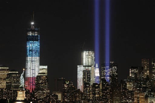 The Tribute in Light shines above the World Trade Center and the Statue of Liberty left Monday Sept. 10 2012 as seen from Bayonne N.J. Tuesday will mark the eleventh anniversary of the terrorist attacks of Sept. 11 2001. The tallest tower is 1 Wor