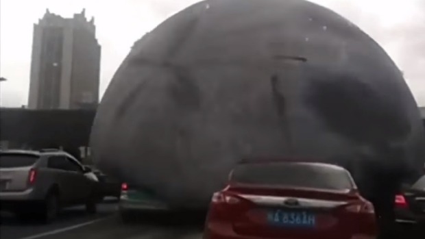 The balloon appeared to envelope everything in its path as it bounced down a busy street in China