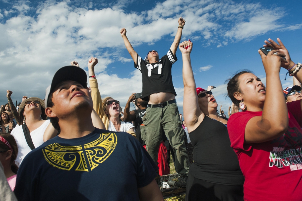 People raise their fists in the air in solidarity as a group of canoes arrives in a protest camp that sprang up to demonstrate against the Energy Transfer Partners’ Dakota Access oil pipeline near the Standing Rock Sioux Reservation in Cannon Ball Nort