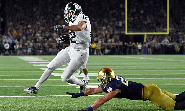 SOUTH BEND IN- SEPTEMBER 17 R.J. Shelton #12 of the Michigan State Spartans scores a touchdown in front of Drue Tranquill #23 of the Notre Dame Fighting Irish during the first half of a game at Notre Dame Stadium