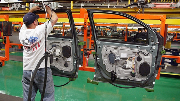 A worker assembles doors at a Ford plant