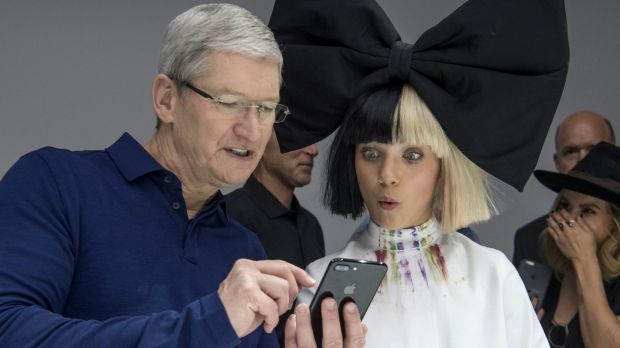 Tim Cook chief executive officer of Apple holds an iPhone 7s while speaking with dancer Maddie Ziegler