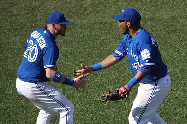 Josh Donaldson #20 of the Toronto Blue Jays celebrates their victory with Edwin Encarnacion #10 during MLB game action against the Minnesota Twins