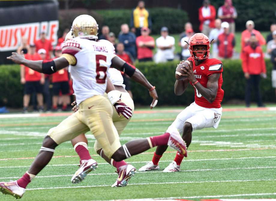 Louisville's Lamar Jackon looks for an open receiver while avoiding the defense of Florida State's Matthew Thomas in the first quarter of an NCAA college football game Saturday Sep. 17 2016 in Louisville Ky. ORG XMI