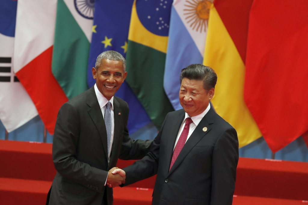 U.S. President Barack Obama left shakes hands with China's President Xi Jinping before a group