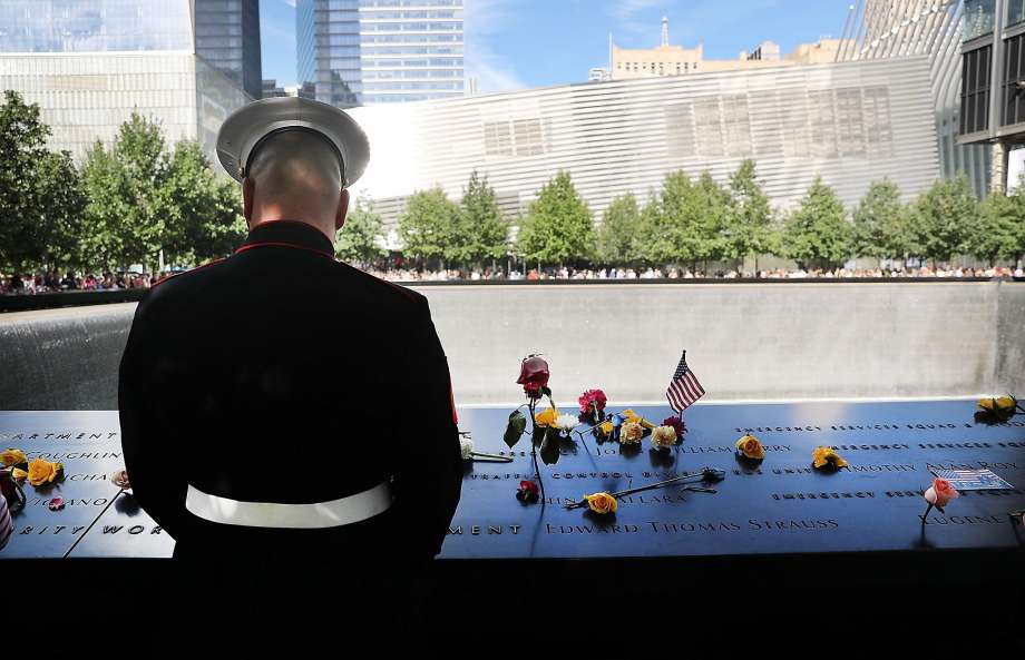 NEW YORK NY- SEPTEMBER 11 A U.S. Marine pauses at one of the pools at the National September 11 Memorial following a morning commemoration ceremony for the victims of the terrorist attacks fifteen years after the day