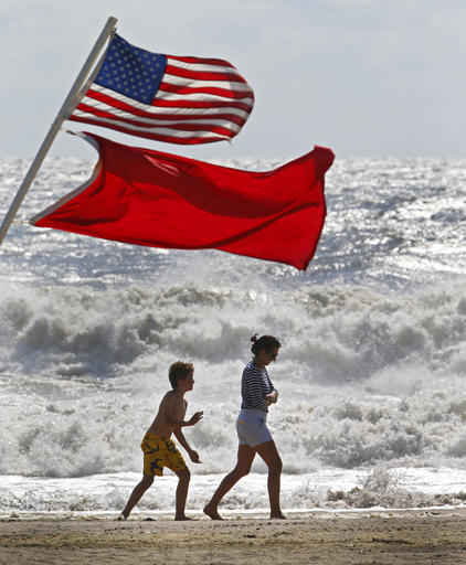 Beachgoers walk away from big waves and rough surf caused by Hermine Sunday Sept. 4 2016 in Bradley Beach,N.J. No swimming was allowed because of the passing storm