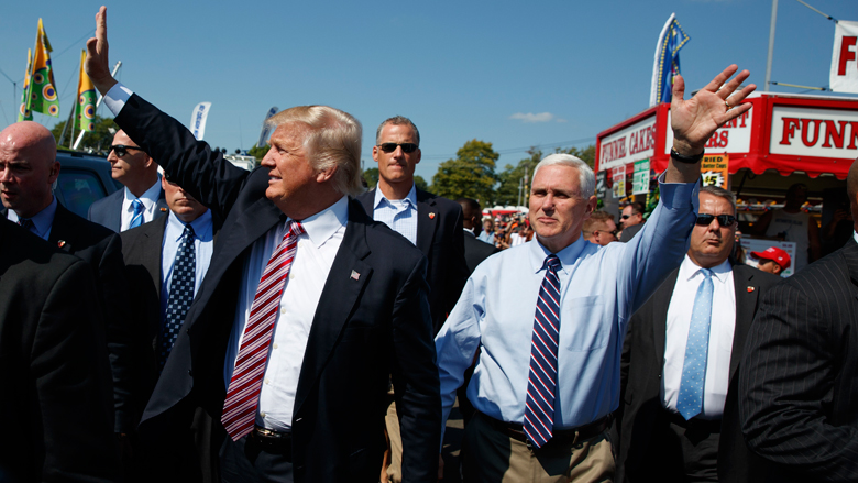 Republican presidential candidate Donald Trump center left waves as he walks with vice presidential candidate Gov. Mike Pence R-Ind. center right during a visit to the Canfield Fair Monday Sept. 5 2016 in Canfield Ohio