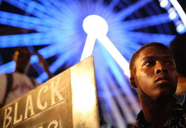 CORRECTS NAME TO TERENCE CRUTCHER A demonstrator holds a sign during a protest in Atlanta on Friday Sept. 23 2016 in response to the police shooting deaths