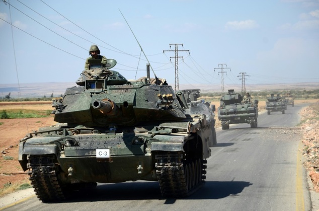 Turkish troops drive their tanks on a road near the Syrian village of al Waqf and some 3km south of al-Rai the small border town with Turkey