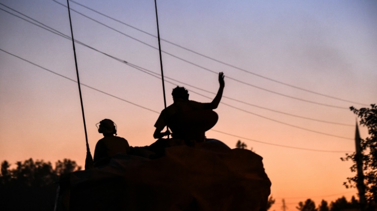 Soldiers stands in a tank driving back to Turkey from the Syrian Turkish border town of Jarabulus