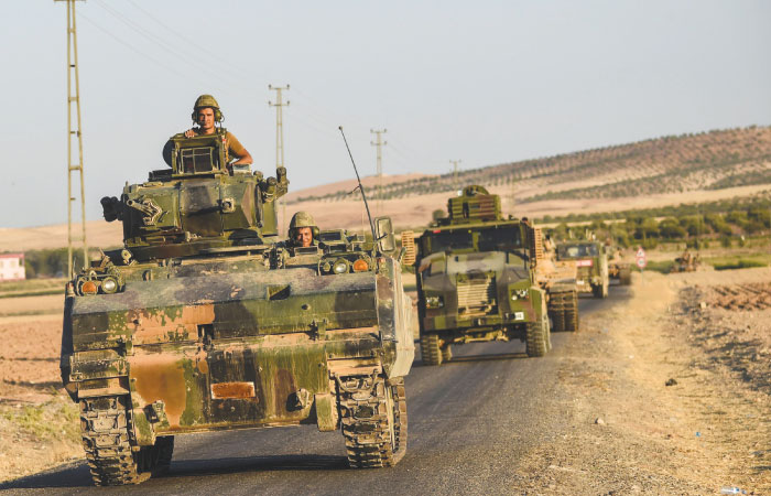 Turkish soldiers stand in a Turkish army tank driving back to Turkey from the Syrian Turkish border town of Jarabulus on Friday in the Turkish Syrian border town of Karkamis. — AFP