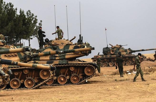 Turkish Army soldiers walking by tanks near Turkish Syrian border of Karkamis