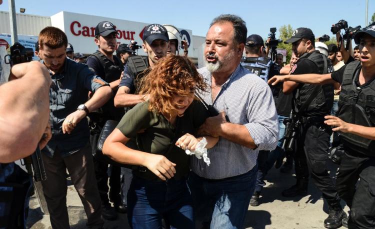 Turkish police officers detain a woman in Diyarbakir on Friday during a protest