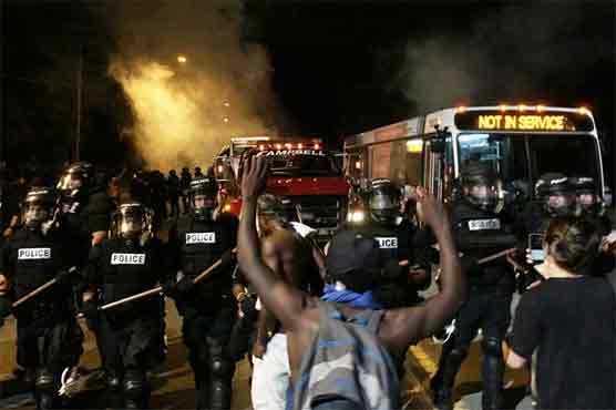 Twelve officers have been injured during protests in N Carolina sparked by the fatal police shooting