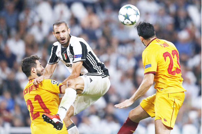 Juventus’ Italian defender Giorgio Chiellini vies for the ball with Sevilla’s Argentinian defender Nicolas Pareja during their UEFA Champions League match at the Juventus Stadium in Turin Wednesday. — AFP