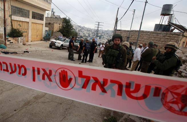 Israeli security forces gather at the scene where a Palestinian stabbed an Israeli soldier before he was shot dead in the flashpoint West Bank city of Hebron