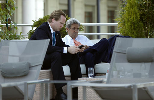 U.S. Secretary of State John Kerry sits beside the hotel swimming pool with aide Jason Meininger right during a break from his meeting with Russian Foreign Minister Sergei Lavrov in Geneva Switzerland to discuss the crisis in Syria Friday Sept. 9 201