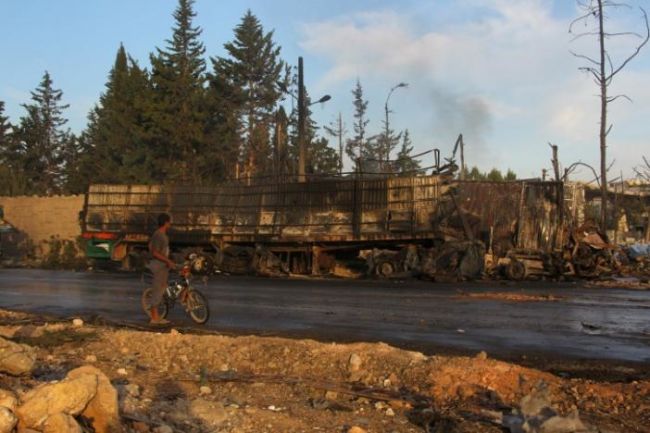 A boy inspects a damaged aid truck after an airstrike on the rebel held Urm al Kubra town western Aleppo city Syria