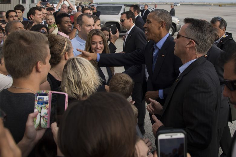 US President Barack Obama shakes hands with spectators as he arrives at John F. Kennedy International Airport in New York NY