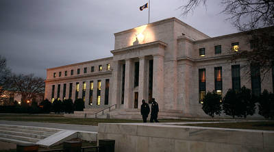 Flags fly over the Federal Reserve Building in Washington D.C. Investors are choosing the route of junk bonds because the Federal Reserve's policy of low interest rates is helping push down yields on safer bonds