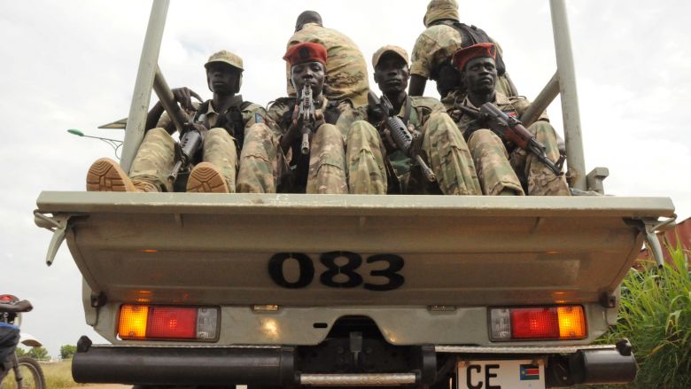 South Sudan National security members ride on their truck as they protect internally displaced people during a reallocation at the United Nations Mission in South Sudan compound at the UN House in Jebel in South Sudan's capital Juba August