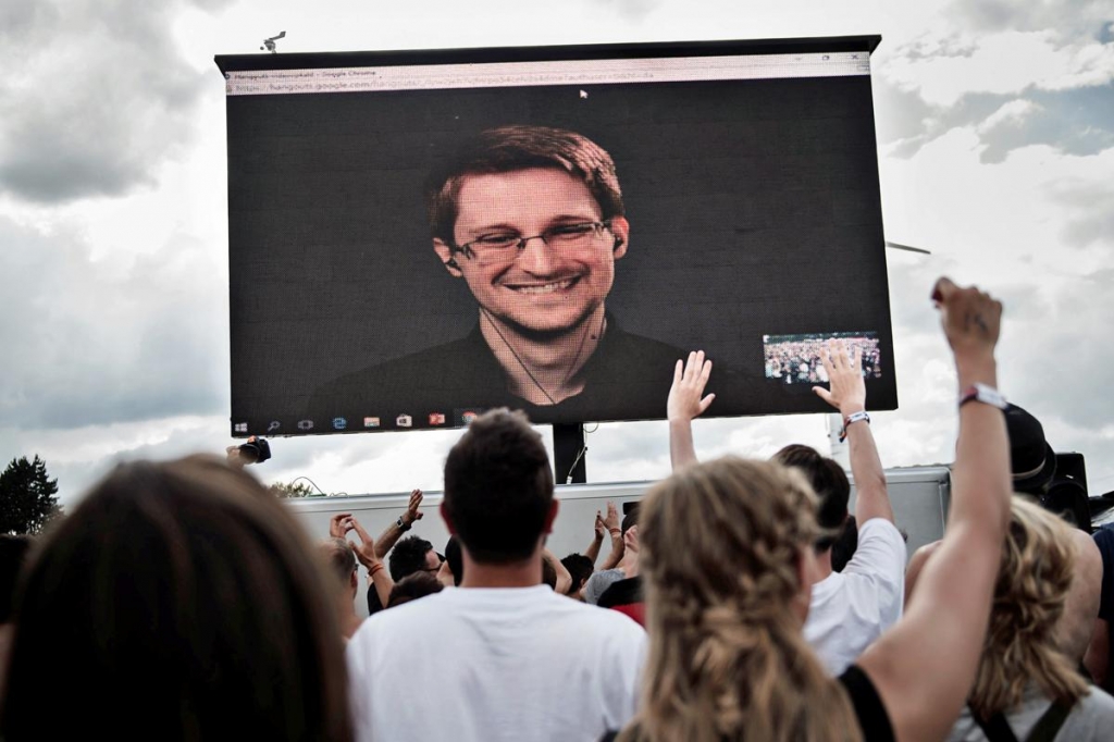 US whistleblower Edward Snowden is seen on a screen as he delivers a speech during the Roskilde Festival