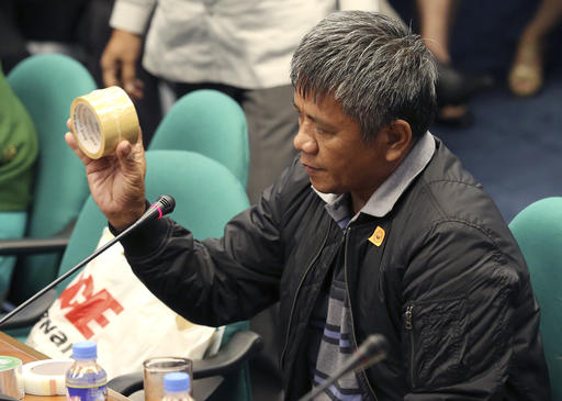 Former Filipino militiaman Edgar Matobato shows the kind of tape they use to wrap up dead bodies as he testifies before the Philippine Senate in Pasay south of Manila Philippines on Thursday Sept. 15 2016. Matobato said that