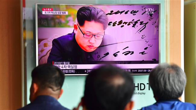 People watch a television news report showing file footage of North Korean leader Kim Jong-un at a railway station in Seoul