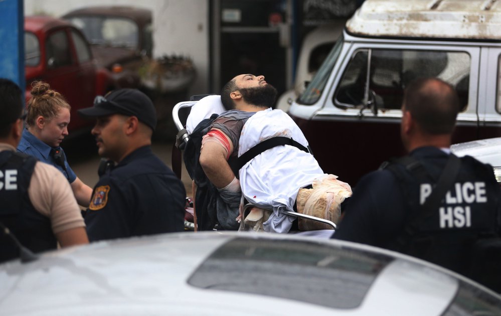 Ahmad Khan Rahami is taken into custody after a shootout with police Monday in Linden N.J. His father said he reported his son as a suspected terrorist to the FBI in 2014 but later retracted his comment and said he believed his son was hanging out with