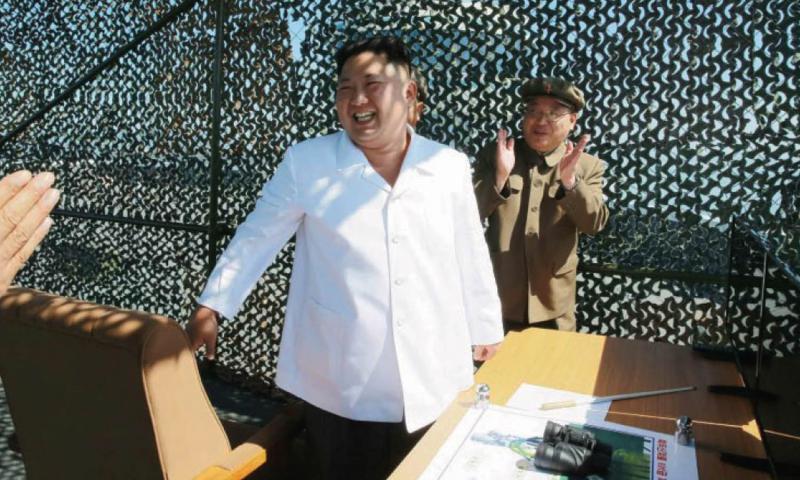 North Korean leader Kim Jong Un receives applause after an apparently successful test of a rocket engine in this