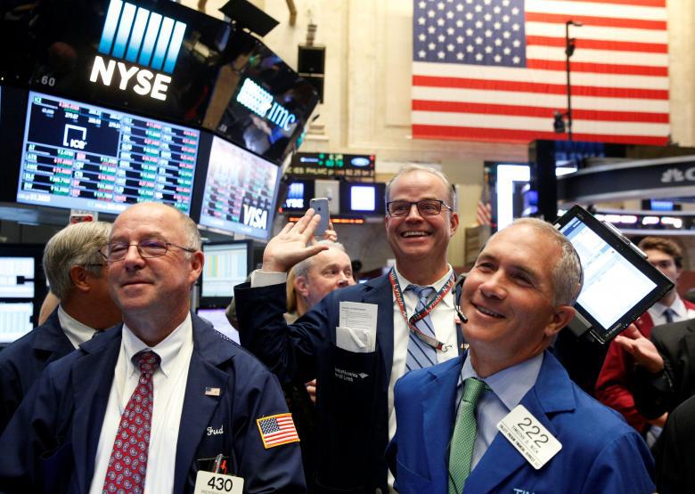 Traders react while working on the floor of the NYSE