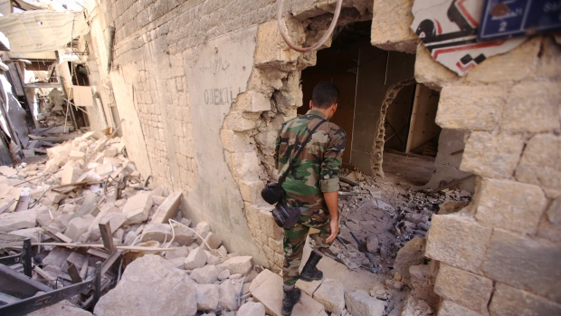 A Syrian government soldier walks in the damaged al Farafira souk in the government-held side of Aleppo's historic city centre