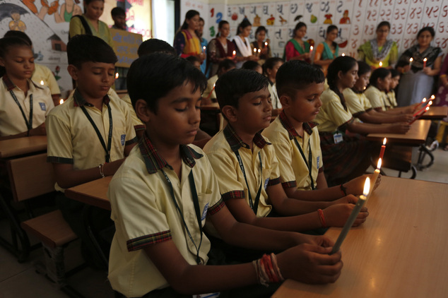 Indian students and teachers holds candles as they pay tribute to the Indian soldiers killed in the Sunday attack on army base in Indian-controlled Kashmir